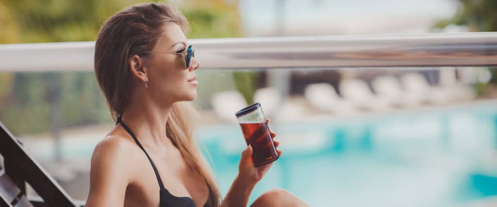 Cliente au bord d’une piscine d’hôtel illustrant l’équilibre entre sobriété hydrique et expérience client